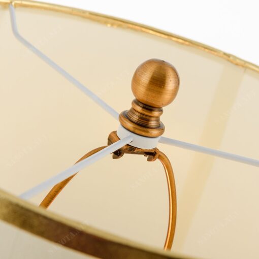 chiếc đèn có thiết thân oval vàng đồng và chao đèn được làm bằng vải, một thiết kế đơn giản nhưng tinh tế khi mang cả nét cổ điển và hiện đại