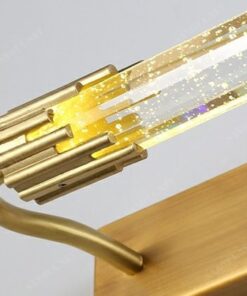 chiếc đèn gắn tường có thiết kế thân đèn bằng đồng mạ vàng, chao đèn là ống pha lê trong suốt