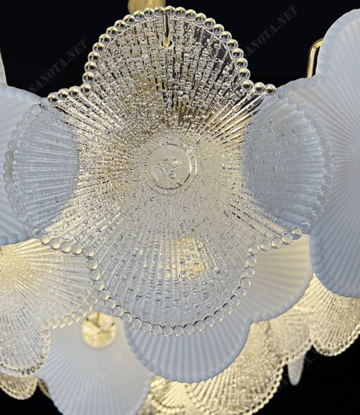 chiếc đèn chùm với thiết kế nhiều tầng bông hoa pha lê bốn cánh xếp xen kẽ nhau giữa hoa pha lê trong suốt và hoa pha lê trắng tạo thành một vòng tròn độc đáo