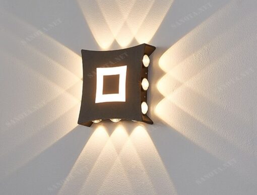 một chiếc đèn hắt tường với thiết kế là một hình tứ giác màu đen viền trắng đơn giản có những bóng đèn cob ở các cạnh