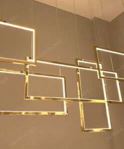 chiếc đèn với thiết kế là những hình vuông bằng đồng mạ vàng được cố định trên trần nhà một cách chắc chắn, một vẻ đẹp sang trọng