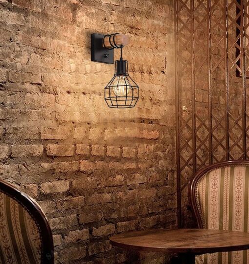 một chiếc đèn gắn tường với thiết kế mang đậm chất cổ điển nhưng pha chút hiện đại kiểu dáng là một lồng đèn được làm từ sắt sơn tĩnh điện màu đen, chiếc lồng đèn được cố định với khúc gỗ trên tường một cách chắc chắn, thiết kế này mang đến cho chiếc đèn mang vẻ đẹp cổ điển độc đáo sang trọng