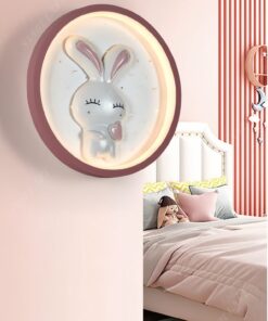 một chiếc đèn gắn tường là một mâm đèn led tròn có thiết kế chú thỏ trắng ở bênn trong vòng tròn kết hợp với đường viền màu hồng, một chiếc đèn phù hợp cho căn phòng của bé gái dễ thương đáng yêu