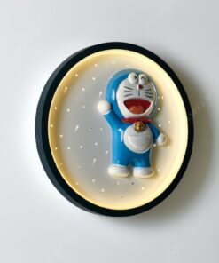 một chiếc đèn gắn tường là mâm đèn led tròn viền đen có thiết kế hình Doraemon dễ thương. Khi chiếc đèn được bật là lúc ánh sáng của bóng đèn Led được phát ra tạo một không gian ấm áp dễ chịu cho căn phòng ngủ. Một chiếc đèn phù hợp cho cả phòng bé trai và bé gái
