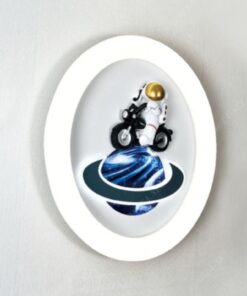 một chiếc đèn gắn tường led dành cho phòng của các bé trai có thiết kế là một mâm đèn led tròn có điểm nhấn trung tâm là một phi hành gia thám hiểm vũ trụ bằng chiếc moto một hình ảnh dí dỏm và dễ thương