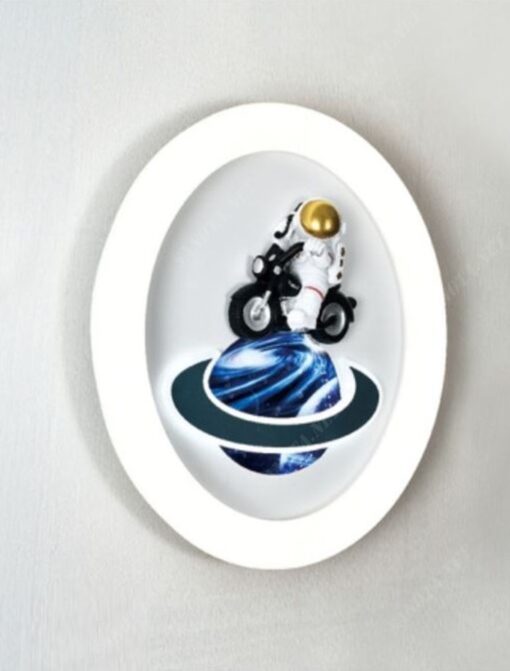 một chiếc đèn gắn tường led dành cho phòng của các bé trai có thiết kế là một mâm đèn led tròn có điểm nhấn trung tâm là một phi hành gia thám hiểm vũ trụ bằng chiếc moto một hình ảnh dí dỏm và dễ thương