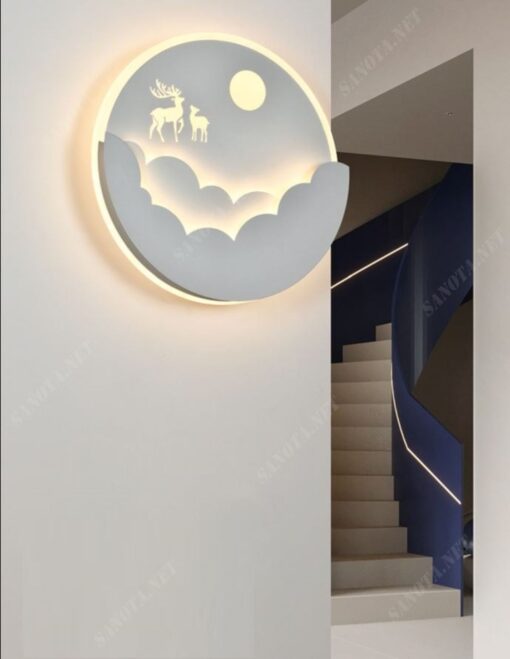 một chiếc đèn gắn tường với thiết kế là một mâm đèn led hình tròn được tô điểm bới hình ảnh 3D những đám mây, ánh trăng, những chú hươu. Khi chiếc đèn được bật là lúc một bức tranh ánh sáng được hiện lên chiếc đèn như một bức tranh đêm rằm trăng tròn có những chú hươu đang nhảy múa, một chiếc đèn gắn tường hiện đại phù hợp với mọi không gian sống đặc biệt là cho việc trang trí phòng khách vừa là đèn vừa vật trang trí