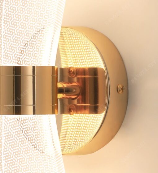 một chiếc đèn gắn tường với thiết kế hiện đại và sang trọng, với điểm tựa chắc chắn bằng đồng mạ vàng sáng bóng được gắn cố định chắc chắn vào tường và chao đèn là thuỷ tinh trong suốt, khi chiếc đèn được bật là lúc chiếc đèn sáng lấp lánh giữa không gian, đây chắc chắn sẽ là một chiếc đèn đủ để thắp sáng cho không gian mà nó được đặt, trang trí đầu giường ngủ, hai bên kệ tivi hay nhiều nơi khác