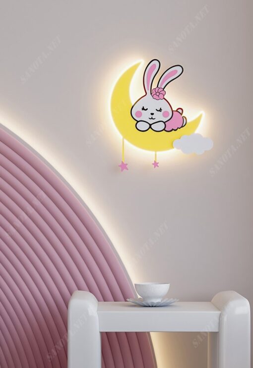 một chiếc đèn gắn tường dành cho phòng của bé là một chiếc đèn LED có thiết kế hiện đại độc đáo và dễ thương, với hình ảnh một chú thỏ hồng đang nằm ngủ trên trăng khuyết, một hình ảnh ngây thơ hồn nhiên và dễ thương,khi chiếc đèn được bật à lúc nó toả sáng giữa không gian căn phòng khi ánh sáng phát ra dịu nhẹ và ấm áp kết hợp với màu sắc hài hoà của chiếc đèn màu hồng của chú thỏ màu vàng của vầng trăng và màu trắng của áng mấy một sự kết hợp vô cùng tinh tế, với chiếc đèn gắn tường led này sẽ phù hợp với nhiều gian phòng khác nhau theo phong cách nhỉ nhảnh dễ thương và đặc biệt sẽ rất phù hợp với phòng của các bé gái, đây sẽ là một chiếc đèn cũng như là món đồ trang trí mà các bé sẽ rất thích