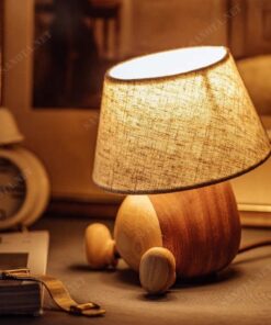 chiếc đèn để bàn hiện đại với thiết kế đơn giản sử dụng chất liệu thân đèn bằng gỗ và chao vải, chiếc đèn sẽ vừa là chiếc đèn thắp sáng cho không gian sống của bạn vừa là món đồ trang trí tạo nên một điểm nhấn đặc biệt thu hút sự chú ý của mọi người. Không gian nội thất hay ngoại thất là điều bạn lưu tâm nhất trong việc tạo ra không gian sống. Một không gian được bày bố hợp với ý tưởng của bạn là điều tuyệt vời. Sẽ tuyệt vời hơn nếu không gian ấy được màu sắc của ánh sáng chiếu rọi. Chiếc đèn bàn gỗ này sẽ là lựa chọn lý tưởng cho không gian sống năng động tươi trẻ của bạn, phù hợp cho phòng ngủ ấm áp, hay phòng khách sang trọng, cả phòng làm việc hiện đại. Với sự phong phú về kiểu dáng thiết kế, ngôi nhà bạn sẽ thêm xinh đẹp. Với công nghệ chiếu sáng hiện đại, không gian của bạn sẽ bừng sáng nổi bật