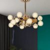Đèn chùm kết hợp quạt với phần khung kim loại được phủ lớp mạ vàng sáng bóng, đèn mang đến vẻ đẹp sang trọng đầy cuốn hút. Cấu trúc nhiều nhánh vươn ra mềm mại như cành cây đang bung nở, nâng đỡ những chao đèn hình cầu bằng thủy tinh đục chạm khắc tinh tế. Mỗi chi tiết đều toát lên sự chăm chút, kỹ lưỡng và hài hòa. Khung đèn được làm từ hợp kim chống gỉ sét, phủ lớp mạ vàng chống oxy hóa giúp giữ màu bền bỉ theo thời gian. Chao đèn thủy tinh dày, an toàn và dễ dàng vệ sinh. Đây là sản phẩm không chỉ đẹp mắt mà còn có tuổi thọ cao, tiết kiệm điện năng, phù hợp với xu hướng tiêu dùng bền vững ngày nay.