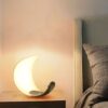 Đèn bàn phòng ngủ gây ấn tượng mạnh ngay từ cái nhìn đầu tiên với thiết kế hình lưỡi liềm uốn cong mềm mại. Mô phỏng hình ảnh vầng trăng đang tỏa sáng. Thân đèn sử dụng chất liệu nhựa cao cấp phủ mờ, giúp ánh sáng lan tỏa dịu nhẹ, không gây chói mắt. Rất thích hợp cho không gian phòng ngủ, nơi bạn cần sự thư giãn, nhẹ nhàng sau một ngày dài làm việc.