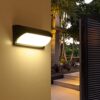 Đèn tường ngoài trời hiện đại được thiết kế với kiểu dáng bo cong mềm mại cùng lớp vỏ nhôm đúc sơn tĩnh điện màu đen tinh tế. Mẫu đèn tường này mang đến cảm giác chắc chắn và hiện đại. Phần chụp đèn bằng kính mờ cao cấp giúp tán đều ánh sáng. Tạo nên hiệu ứng chiếu sáng dịu nhẹ nhưng vẫn đủ sáng cho lối đi, bậc thềm hay tường rào. Ánh sáng vàng ấm không chỉ làm nổi bật không gian ngoại thất mà còn tạo nên cảm giác thân thiện, dễ chịu khi bước vào nhà.