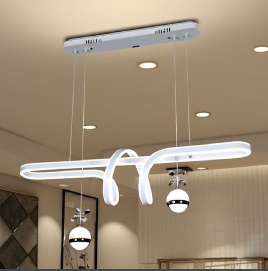 Đèn chùm bàn ăn trang trí không gian hiện đại được thiết kế với cấu trúc uốn lượn mềm mại. Mang đậm dấu ấn nghệ thuật hình khối hiện đại. Đường nét LED chạy dọc thanh đèn được bo cong tinh xảo như một dải lụa ánh sáng bay lượn giữa không trung. Kết hợp cùng hai quả cầu ánh sáng treo thả đối xứng được nhấn bằng chi tiết trang trí kim loại. Tạo nên một tổng thể hài hoà giữa hiện đại và độc đáo.