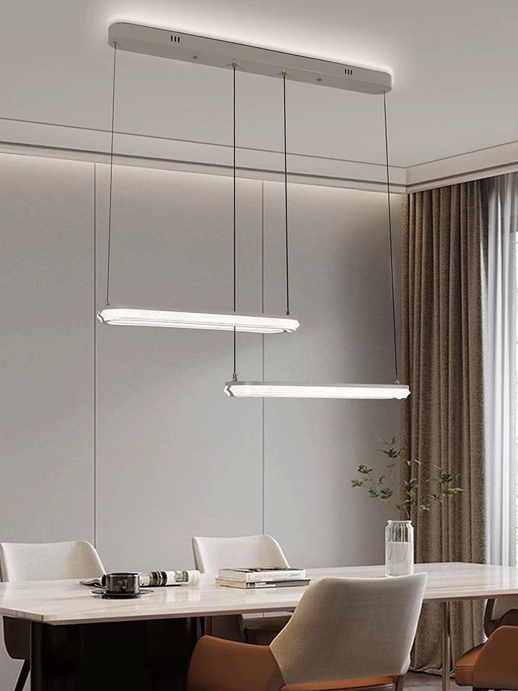 Đèn chùm LED thanh dài hiện đại đem lại sự cuốn hút bởi thiết kế hình khối thanh ngang đơn giản nhưng đầy tinh tế. Hai thanh đèn được bố trí so le nhau tạo nên hiệu ứng thị giác cân đối và phá cách. Dây treo mảnh mai, kết hợp cùng phần đế gắn trần sơn trắng tinh tế giúp tổng thể đèn trở nên "nhẹ" và hiện đại. Rất phù hợp với những không gian tối giản, nội thất phong cách Bắc Âu hoặc đương đại.