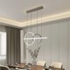 Đèn chùm hiện đại gây ấn tượng mạnh với kiểu dáng vòng tròn lồng ghép tinh tế. Kết hợp cùng thanh đèn LED ngang tạo nên một tổng thể hài hòa nhưng không kém phần độc đáo. Mỗi đường nét đều được chăm chút kỹ lưỡng, mang đậm phong cách minimalist hiện đại. Sự giao thoa giữa nghệ thuật và công năng.