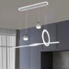 Đèn chùm trang trí không gian bàn ăn được thiết kế với hai chụp tròn kim loại bóng mạ. Kết hợp với một thanh LED mềm mại uốn cong và vòng tròn ánh sáng nổi bật. Mang đậm hơi thở của nghệ thuật đương đại. Sự kết hợp hài hòa giữa thiết kế hình học hiện đại và chất liệu cao cấp tạo nên một tổng thể đẳng cấp, tinh tế, góp phần nâng tầm không gian sống.