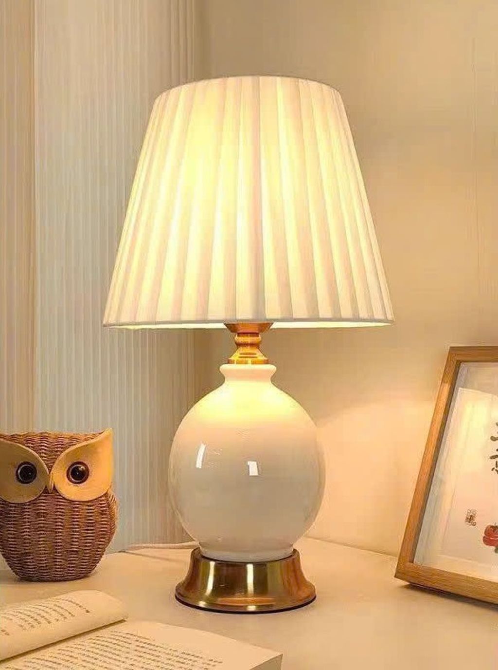 Đèn bàn gốm sứ cao cấp với điểm nhấn thu hút ánh nhìn chính là phần thân đèn được chế tác từ gốm sứ tráng men bóng loáng. Cùng gam màu chuyển sắc nhẹ nhàng, hài hòa. Tông xanh pastel nhạt kết hợp với lớp men loang tinh tế tạo hiệu ứng chiều sâu và cảm giác dịu mắt. Phù hợp với nhiều phong cách nội thất như tân cổ điển, Scandinavian, hay vintage tối giản.