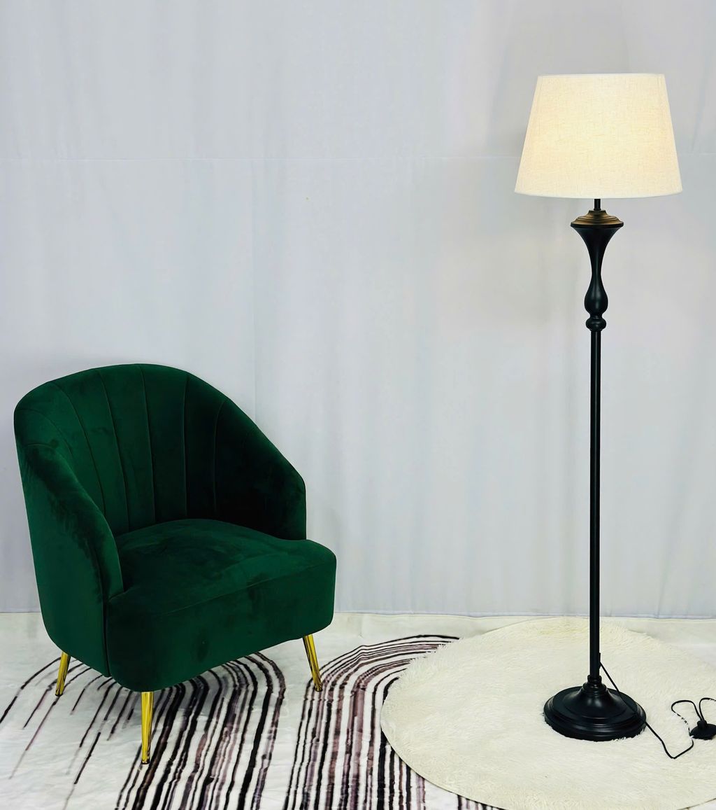Đèn cây trang trí phòng khách lấy cảm hứng từ thiết kế tối giản đậm chất Bắc Âu. Sản phẩm sở hữu thân đèn thẳng đứng màu đen nhám thanh thoát kết hợp cùng chụp đèn vải trắng kem mềm mại. Tạo nên tổng thể hài hòa, nhẹ nhàng nhưng đầy cuốn hút. Chân đèn được thiết kế chắc chắn, đường cong mềm mại ở phần thân như một điểm chấm phá nghệ thuật mang lại vẻ ngoài đầy tinh tế. Sự tương phản màu sắc giữa thân đèn và chao đèn góp phần tạo nên chiều sâu thị giác. Phù hợp với mọi không gian như phòng khách, phòng ngủ hay góc đọc sách.