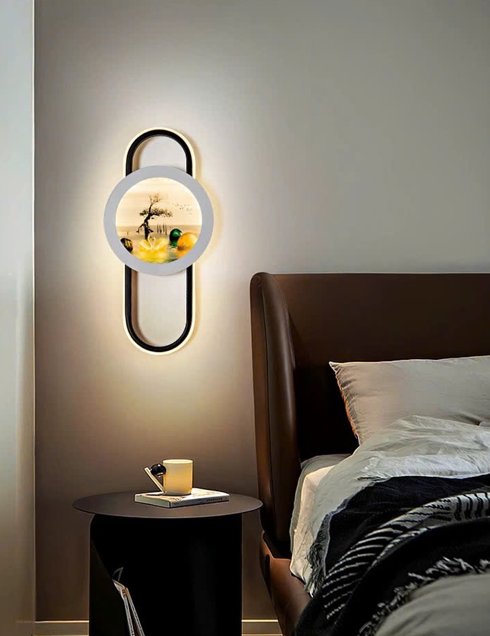 Đèn tường phong cảnh thiên nga gây ấn tượng với thiết kế khung oval hiện đại. Kết hợp mặt tròn trung tâm in hình thiên nga, hồ nước và cây cổ thụ đầy tính nghệ thuật. Sự hòa quyện giữa ánh sáng LED dịu nhẹ và hình ảnh thiên nhiên mang đến cảm giác thư thái, bình yên cho không gian.