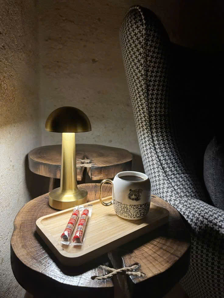 Đèn để bàn mạ vang lấy cảm hứng từ hình dáng cây nấm nhỏ xinh. Đèn để bàn nổi bật với thiết kế tối giản, gọn gàng mà vẫn tinh tế đến từng đường nét. Toàn bộ thân đèn được phủ lớp mạ vàng bóng mượt, phản chiếu ánh sáng nhẹ nhàng. Tạo cảm giác ấm áp và sang trọng cho căn phòng.